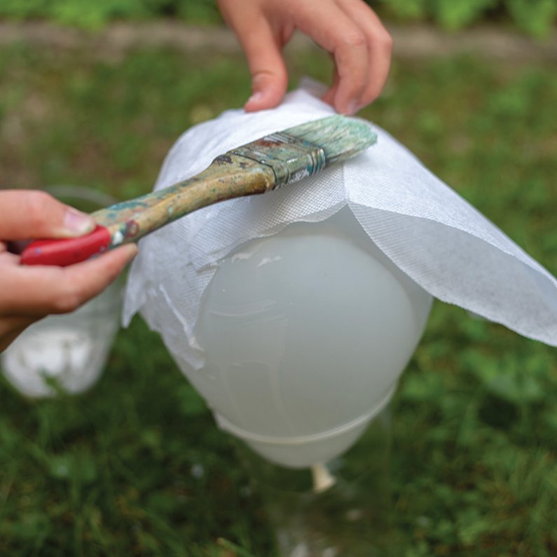 Papirnate prtičke polagaj na balon in jih dobro premaži z lepilom, da bo nastala nekakšna prevleka. 